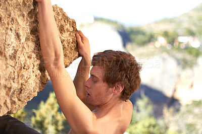 Buy stock photo Profile of a young rock climber hanging off the edge of a cliff