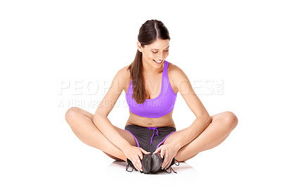 Buy stock photo Studio shot of a young women sitting on the floor and stretching her legs isolated on white