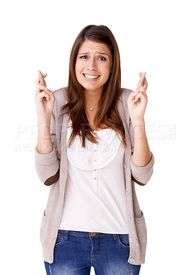 Buy stock photo Casually dressed young woman with her fingers crossed against a white background