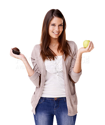 Buy stock photo Portrait, decision and apple or muffin with a woman in studio isolated on a white background for food choice. Smile, diet or nutrition with a happy young person holding fruit and dessert options