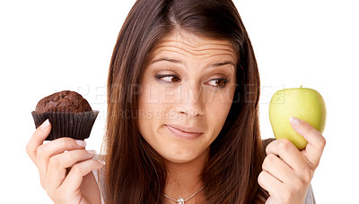 Buy stock photo Face, choice and apple or muffin with a woman in studio isolated on a white background for food decision. Doubt, health or nutrition with a confused young person holding fruit and dessert options