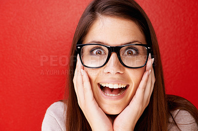 Buy stock photo Portrait, glasses and face of happy woman in surprise for winning, prize or good news against a red studio background. Young friendly or excited female person smile in shock, alert or wow on mockup