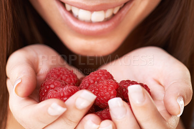 Buy stock photo Cropped image of a happy young woman holding a bunch of raspberries