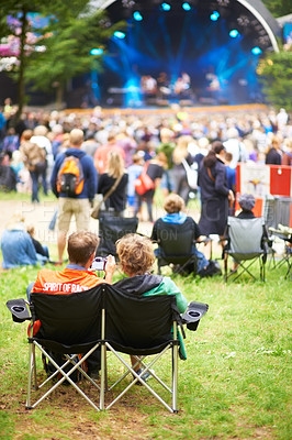 Buy stock photo Rear-view shot of a crowd watching an outdoor show at a music festival