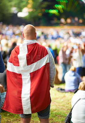 Buy stock photo Back, music festival and a man in the flag of Denmark for celebration at a party or event in summer. Concert, audience or crowd with people outdoor on a field for carnival performance or leisure