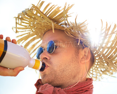 Buy stock photo Man, drinking and alcohol with sunlight outdoor for concert, event or music festival with sunglasses and straw hat. Person, drink and beverage in summer for relax, freedom and enjoyment with sunshine