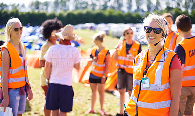 Buy stock photo Shot of a beautiful young woman working as an event assistant at a music festival