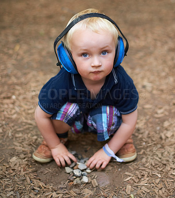 Buy stock photo Protection, boy and outdoor with headphones, portrait and relax with nature, playing and summer. Toddler, kid and childhood with noise cancelling headset, outside and sound in a park and safety