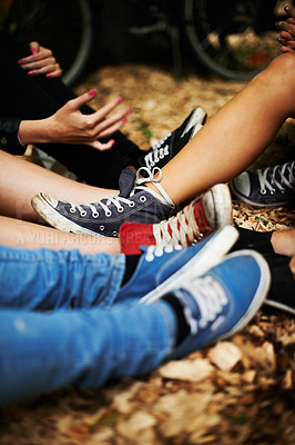 Buy stock photo Sneakers, legs and friends on the ground outdoor in autumn together to relax or chill closeup. Fashion, style and casual with the shoes of a group of people sitting on leaves during the fall season