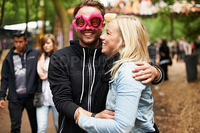 Buy stock photo Happy couple, hug and music festival for love, care or support at crowded party, DJ event or fun park. Man and woman smile in embrace, affection or trust for festive outdoor celebration or holiday