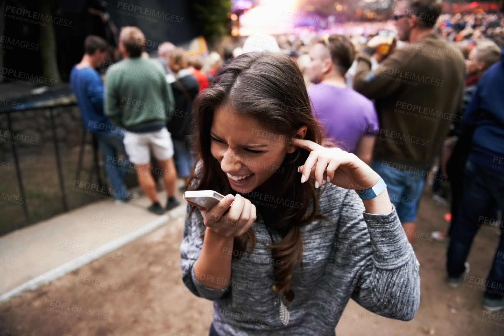 Buy stock photo Music festival, event and woman outdoor with phone call, conversation and noise from concert, crowd or party. Contact, person and confused by loud, sound or listening to smartphone and lost at a rave