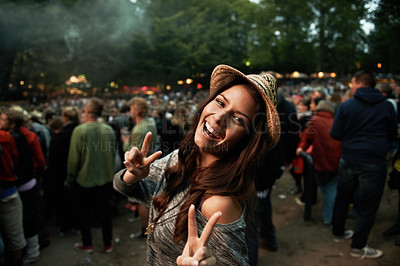 Buy stock photo A pretty young woman showing a peace sign at an outdoor music festival