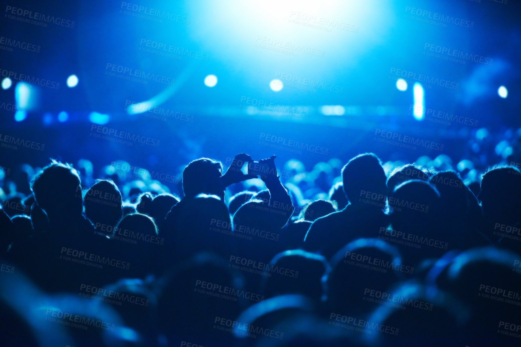 Buy stock photo People, blue and crowd for concert, performance or stage in arena for rock, psychedelic or electric music. Lens flare, light and equipment with person, holding and smartphone for social media post