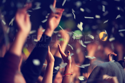 Buy stock photo A music festival audience throwing confetti into the air in celebration