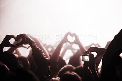 Buy stock photo Hands, heart and phone in the audience with people watching a concert or music festival event. Party, dance or disco with a group of men and women in the crowd while attending a stage performance