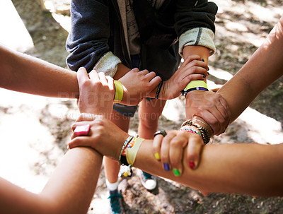 Buy stock photo People, hands together and outdoor festival with arm bands for community, teamwork or unity at event. Group of friends  piling or circle for synergy, motivation or party at music carnival outside