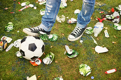 Buy stock photo A person playing with a football amidst the trash left behind at a music festival