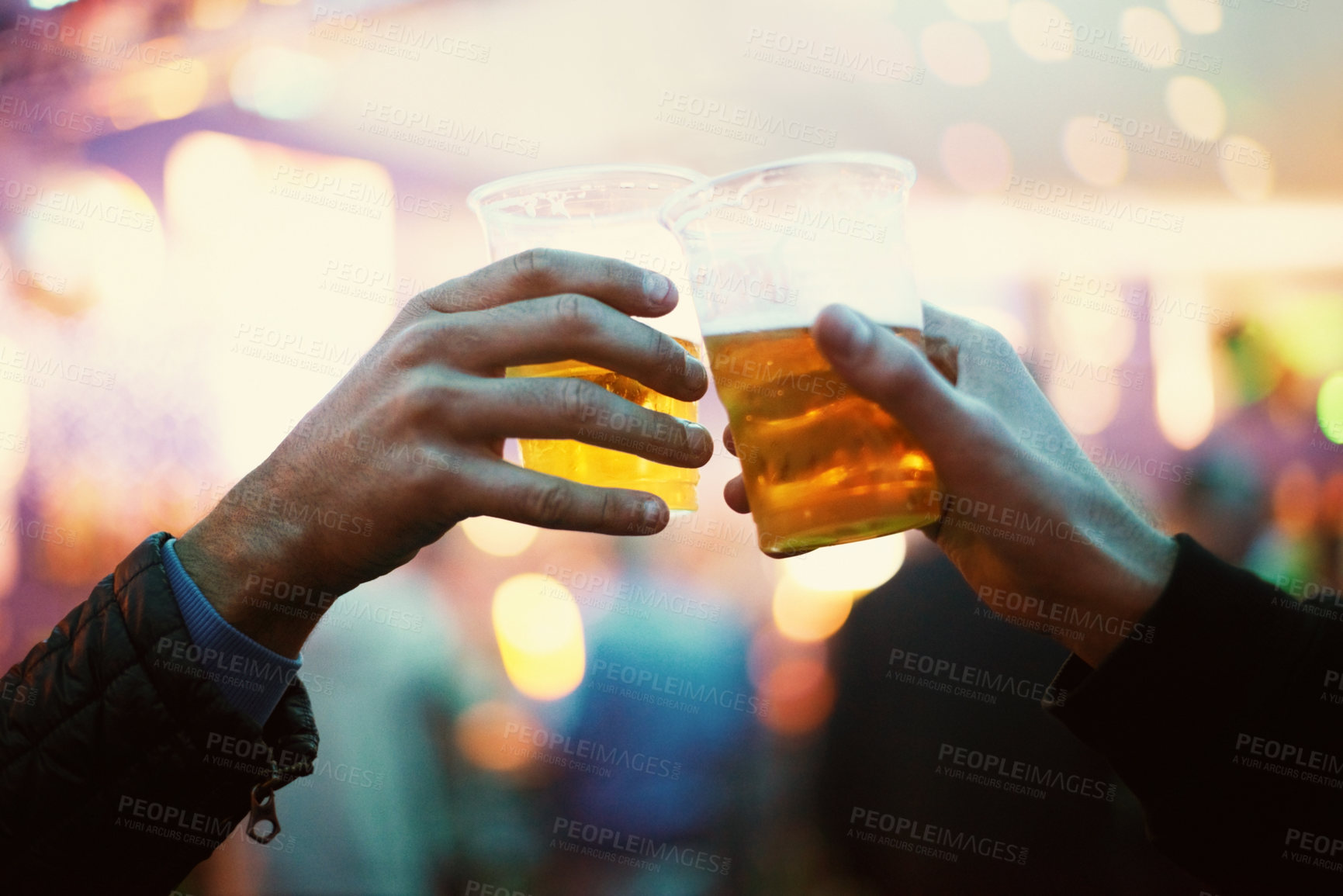 Buy stock photo Two friends toasting to the good times with plastic cups of beer - Music Festival