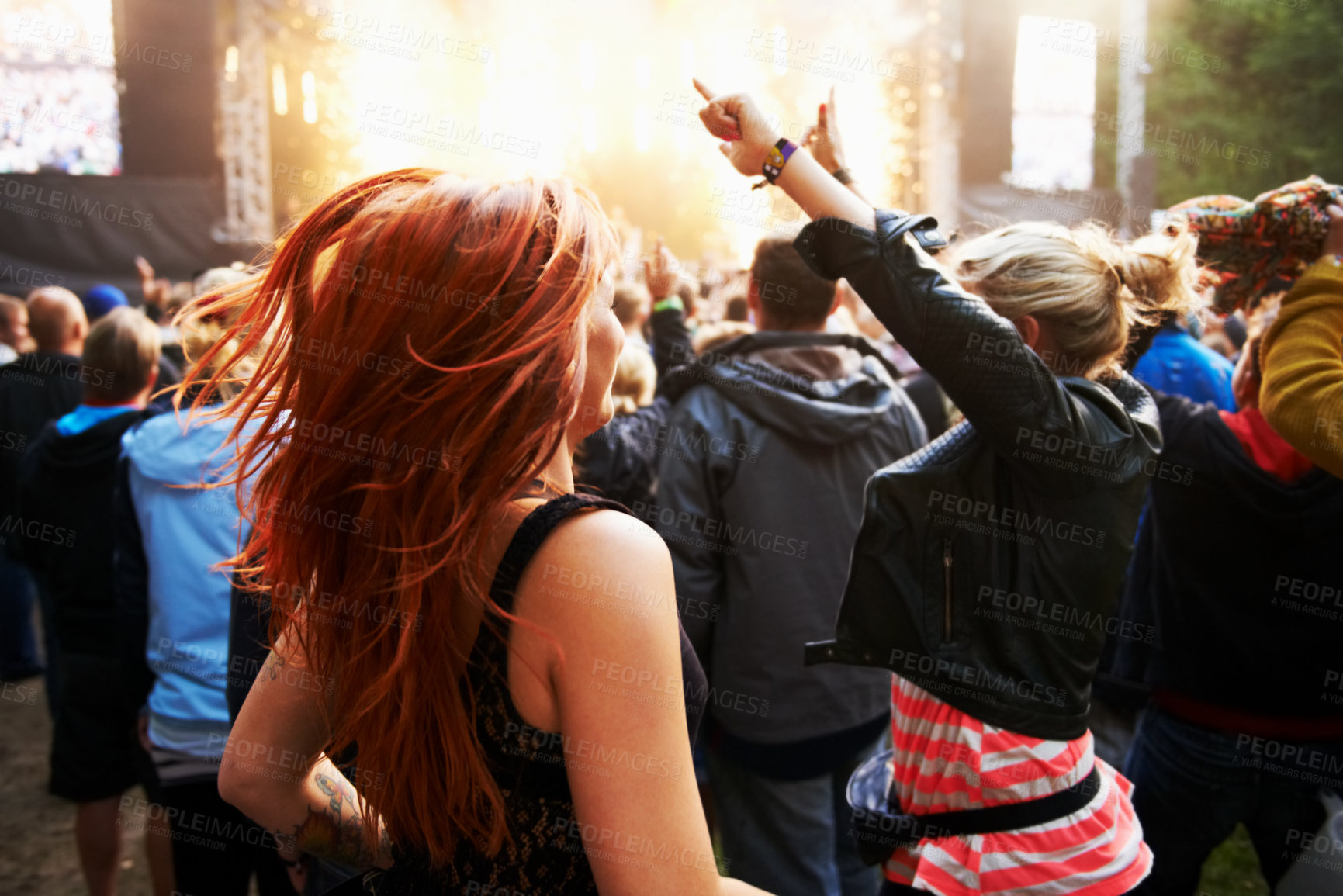 Buy stock photo Rearview shot of a crowd of young people enjoying themselves at an outdoor music festival