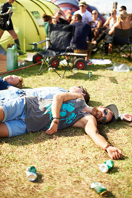 Buy stock photo Shot of a group of guys passed out on the grass surrounded by empty beer cans at an outdoor festival