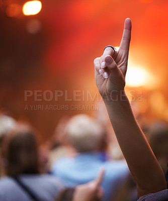 Buy stock photo Closeup, hand and person with music festival, cheering and concert with blur background, party and group. Finger, fan and sign with gesture, event and crowd with praise, celebration and performance