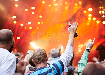 Buy stock photo Rearview shot of a crowd of fans cheering at an outdoor music event