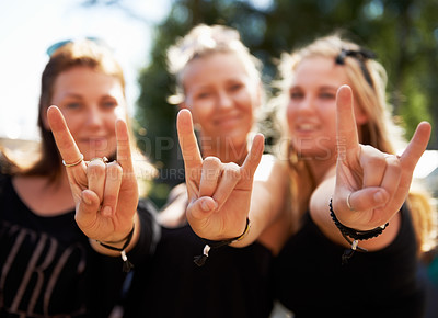 Buy stock photo Friends, portrait and women with rocker hands at a music festival, concert of party outdoor together. Devil horns, emoji and face of female group outside for fun, celebration and rock event in a park