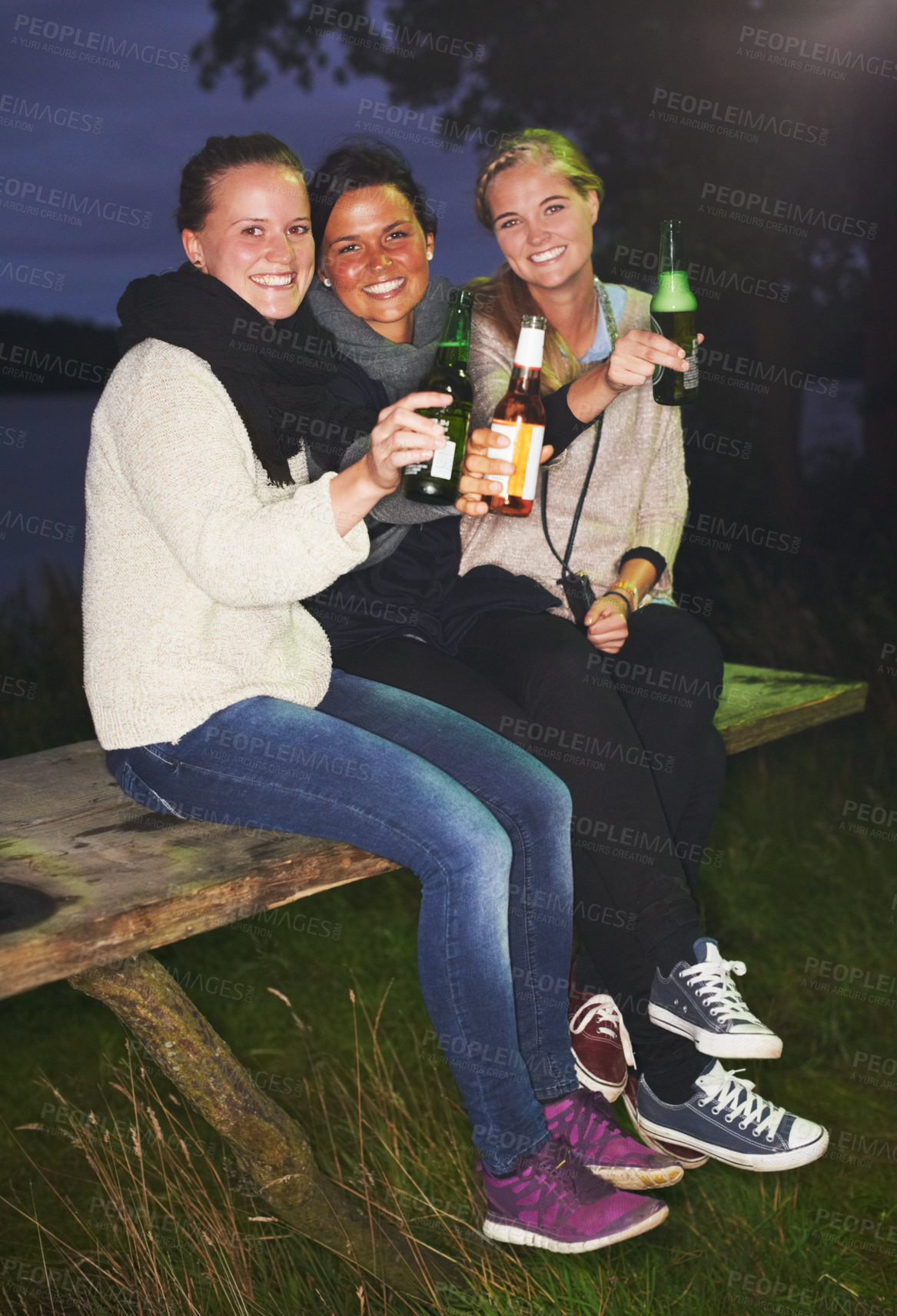 Buy stock photo Friends, portrait and beer outdoor at night for camping adventure, nature celebration or group connection. Woman, face and smile for alcohol drinking or cheers toast for summer, travel or vacation