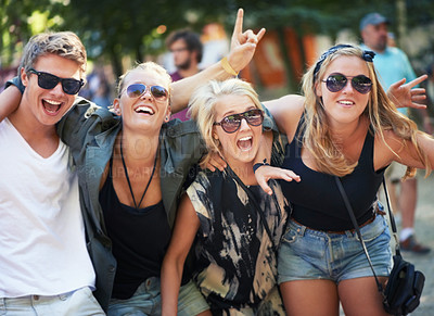 Buy stock photo Four young friends rocking out to a band at a music festival