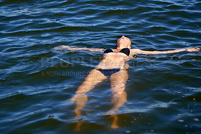 Buy stock photo Ocean, water and woman floating in bikini with peace and freedom in summer, holiday or vacation. Person, relax and calm swimming in sea, lake or pool with swimwear, costume and waves offshore