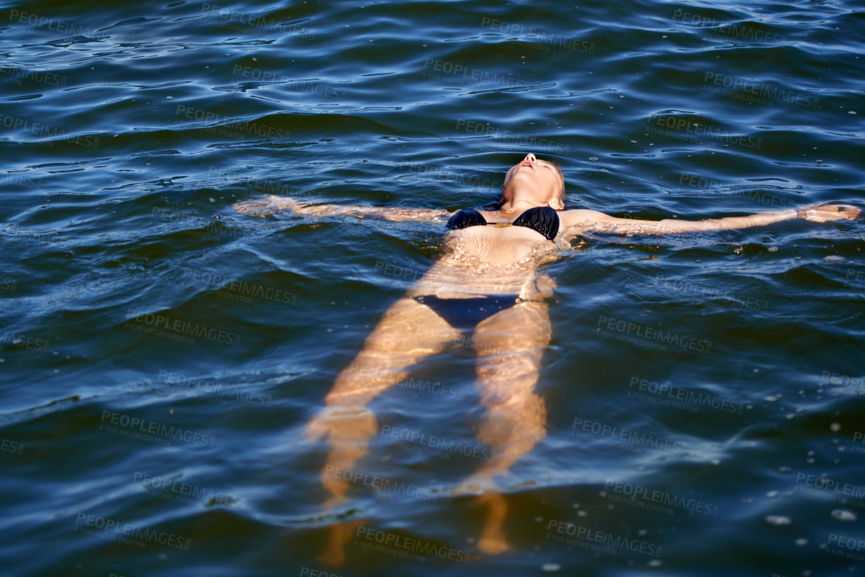 Buy stock photo Ocean, water and woman floating in bikini with peace and freedom in summer, holiday or vacation. Person, relax and calm swimming in sea, lake or pool with swimwear, costume and waves offshore