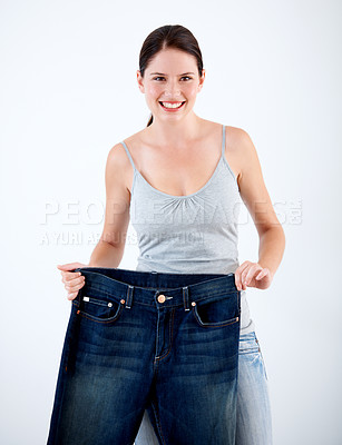 Buy stock photo Jeans, weight loss and portrait of woman with change in size on white background in studio. Body, transformation and person with journey in diet, fitness and healthy results with large denim pants