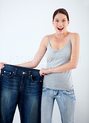 Buy stock photo Surprise, weight loss and woman with jeans, change in size and white background in studio. Wow, shocked and portrait of person with crazy reaction to transformation in fitness or large denim pants