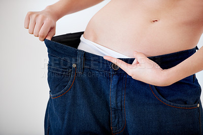 Buy stock photo Cropped image of a woman pulling the waistband of her pants - Weight Loss