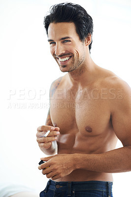 Buy stock photo Smile, cigarette and a shirtless man smoking in studio on a white background for nicotine addiction. Smoke, tobacco and body with a happy young person in the bedroom of his home to relax for leisure