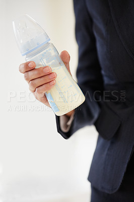 Buy stock photo Business, woman and mom with baby bottle in suit, working and balance a career with motherhood. Hand, closeup and mother with milk in container for child, care and management of family with a job
