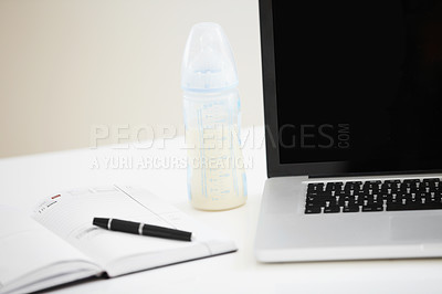 Buy stock photo Cropped image of a laptop with an open diary lying next to it