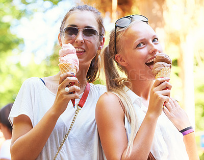 Buy stock photo Cute young teen friends eating ice cream together in the sunshine
