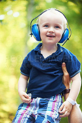 Buy stock photo Cute little boy lifted up by his father while wearing noise-canceling headphones