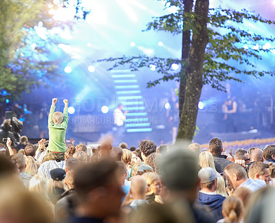 Buy stock photo Rearview shot of a crowd of fans cheering at an outdoor music event
