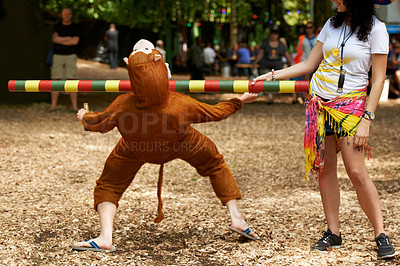Buy stock photo Summer, vacation and man in game of limbo, balance and playing at a music festival, event and challenge. Fun, people and outdoor in woods, forest or person in social activity at party in monkey suit
