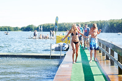 Buy stock photo People walking along a jetty and cooling off in the lake
