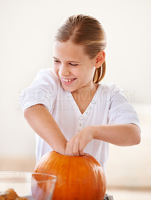 Buy stock photo Girl, child and happy with pumpkin for halloween, celebration or decoration in kitchen of apartment or home. Kid, face and smile with vegetable for preparation, holiday or creative event in house