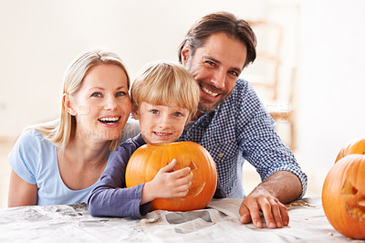 Buy stock photo Portrait of a husband and a wife with their son behind a carved pumpkin
