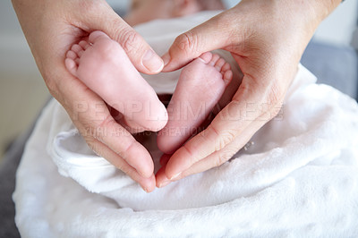 Buy stock photo A mother holding her baby girl's tiny feet in her hands so that it forms a heart