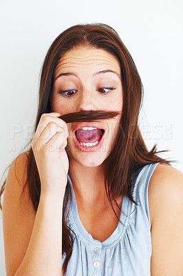 Buy stock photo Woman, silly and playing with hair mustache by white background, hairstyle and funny joke in studio. Female model person, comic and comedy for haircare or goofy, beauty treatment and cosmetology
