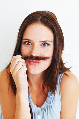Buy stock photo A young woman playing with her hair in the shape of a mustache