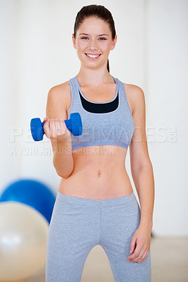 Buy stock photo Portrait of an attractive young woman doing bicep curls with a dumbbell