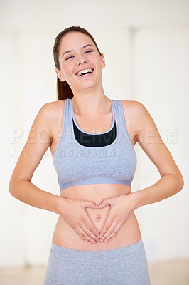Buy stock photo Portrait of a beautiful young woman putting her hands on her stomach