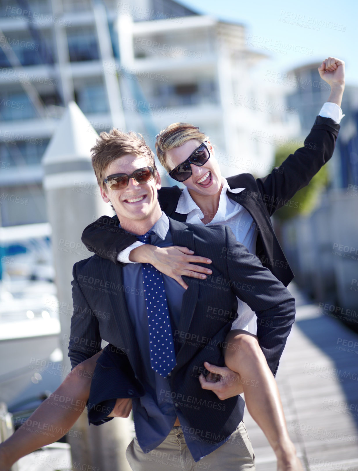 Buy stock photo Piggyback, celebration and couple at harbor excited for success, startup and travel freedom. Business people, victory and cheerful man with woman before traveling in Amsterdam, winning and hand sign